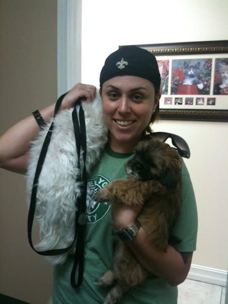 Momma carrying baby Paris home, with Angel the white Maltese over her shoulder