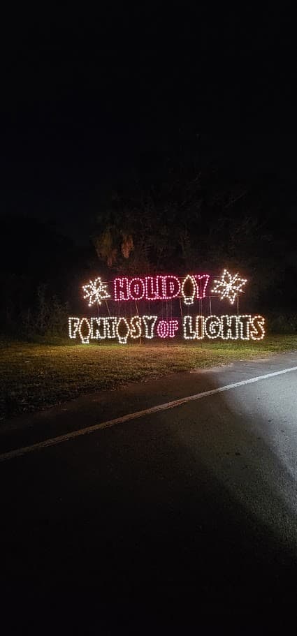 A glowing Holiday Fantasy of Lights sign at night.