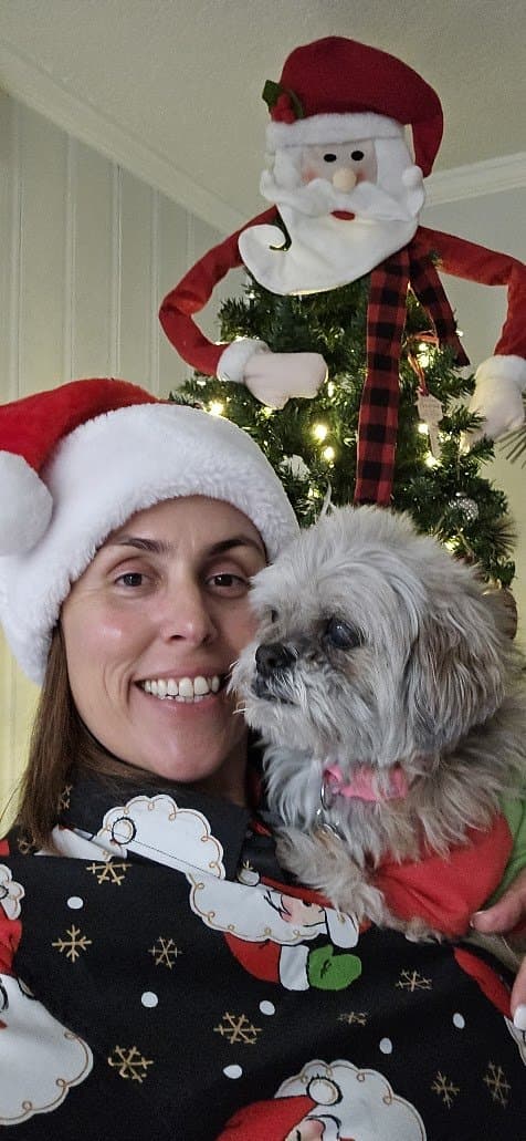 Momma and Paris in Santa hats by the Christmas tree.