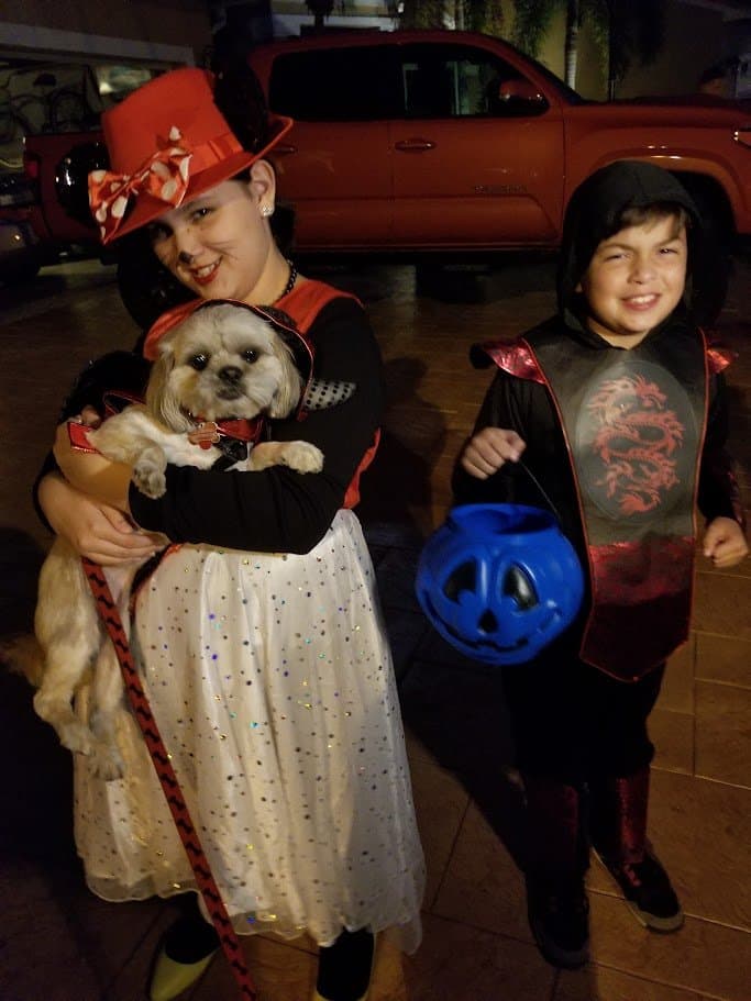 Paris in a little devil costume, held close on Halloween night.