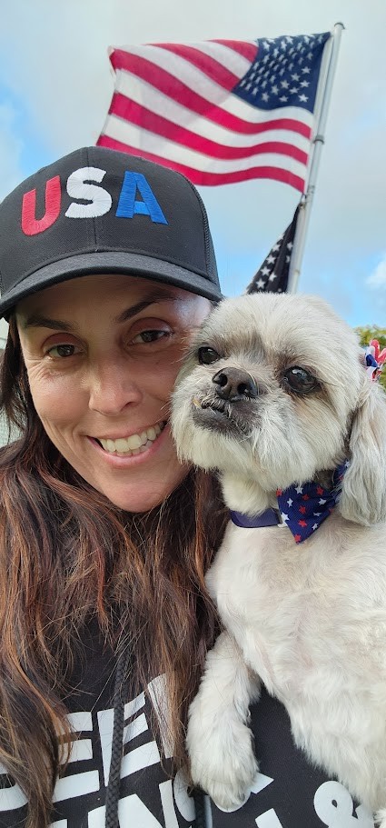 Momma in a USA hat with Paris dressed up for the holiday, an American flag flying behind them on the Fourth of July.