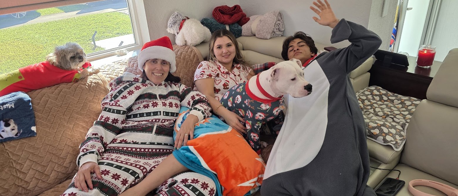 The whole family in matching pajamas on the couch on Christmas morning.