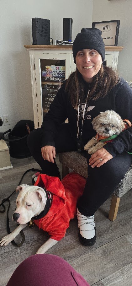 Momma with Paris in her arms and Misty in a red hoodie on the floor, all together indoors